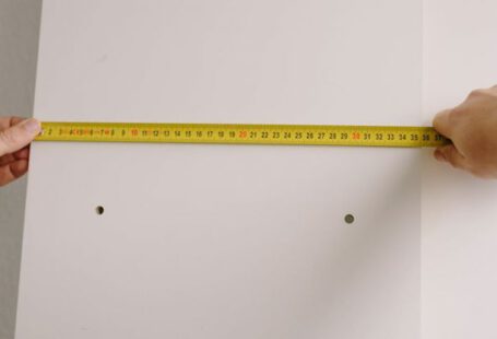 Workplace Change - Crop man measuring wooden board in room