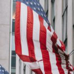 Perseverance - Row of American flags with stripe and star ornament on wall of embassy building in town